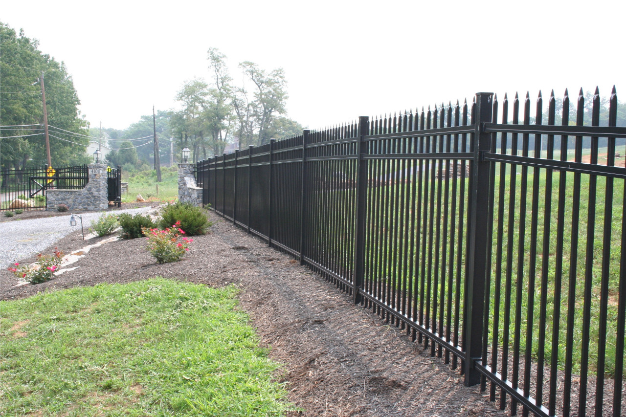 Black aluminum fence running up the side of a flower bed