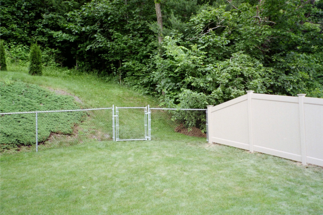 4' high residential vinyl coated chain link fence with 3' gate connecting with 6' high clay privacy fence