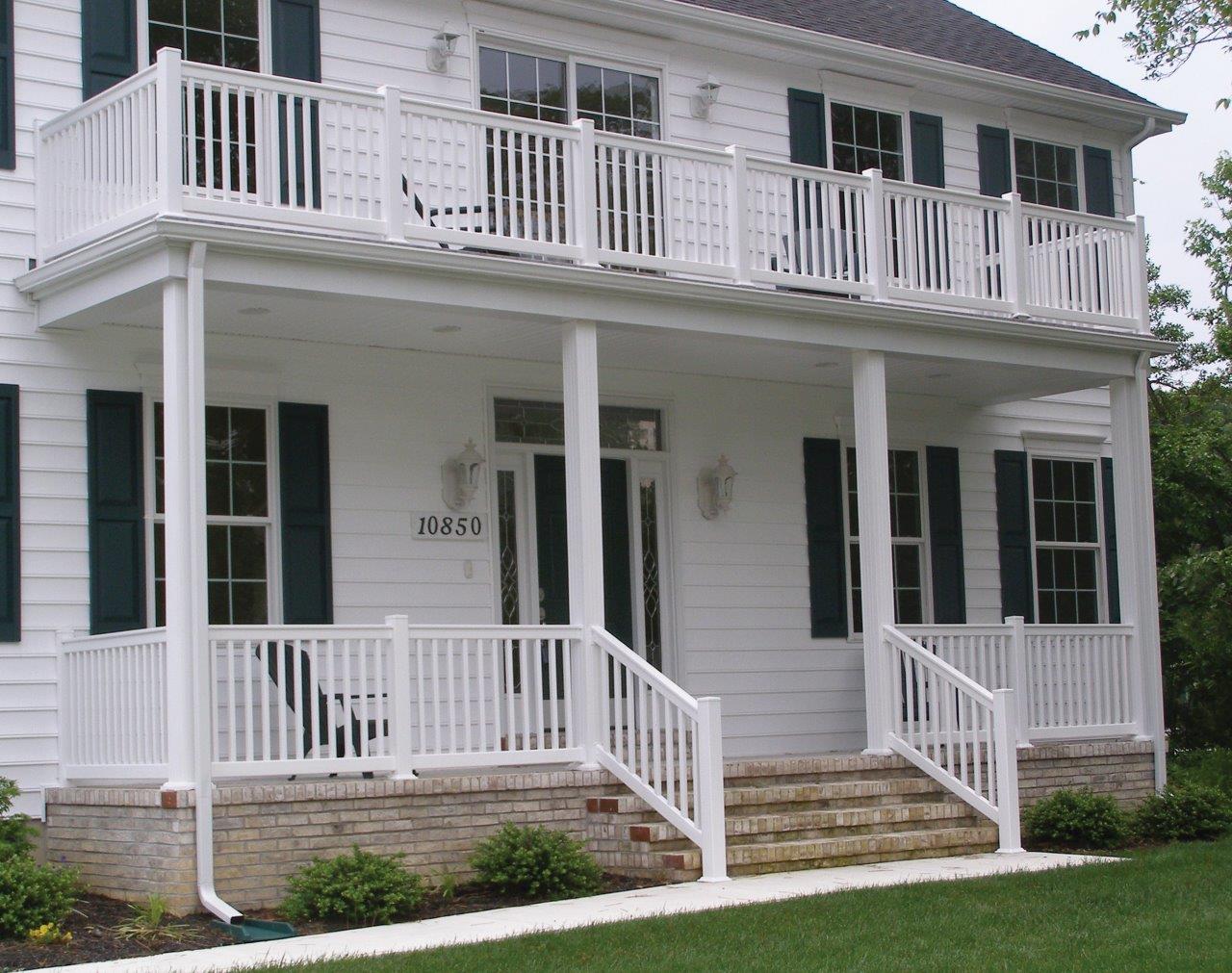 A large two story white house with a porch and a balcony